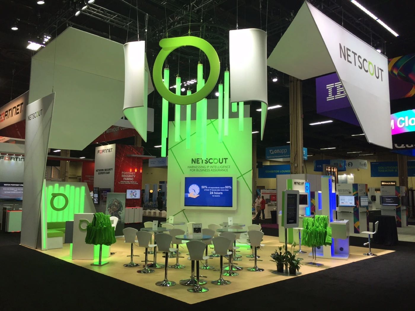 NetScout booth with green lit rings and hanging panels